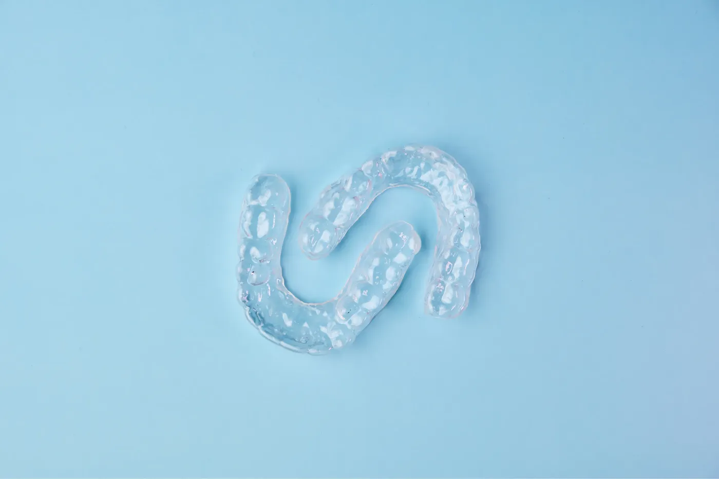 Invisalign clear aligner tray held by a patient at Indian Trace Dental
